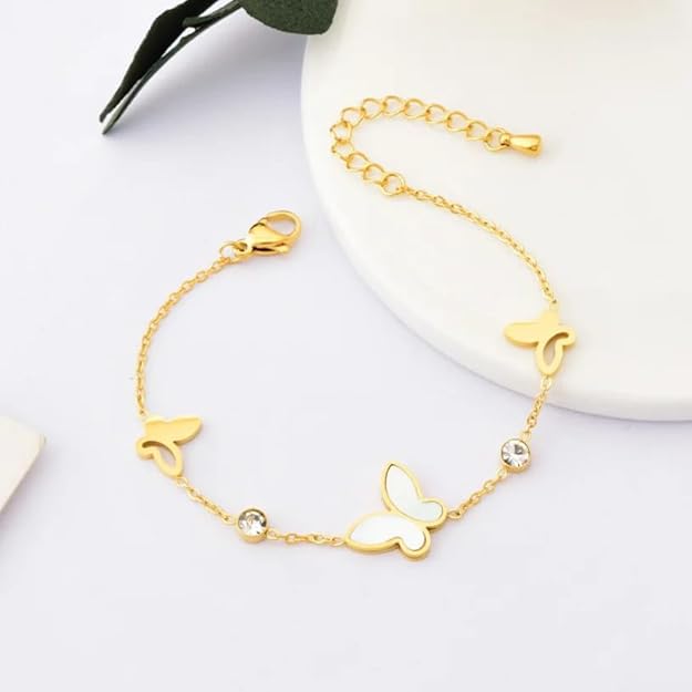 A close-up of a woman's wrist adorned with a gold butterfly bracelet.