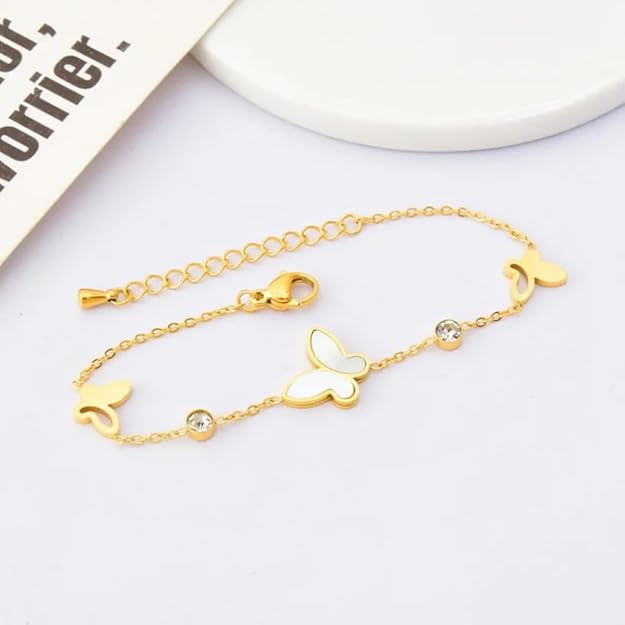 Gold butterfly bracelet on woman's wrist, adding a delicate and stylish touch to her outfit.