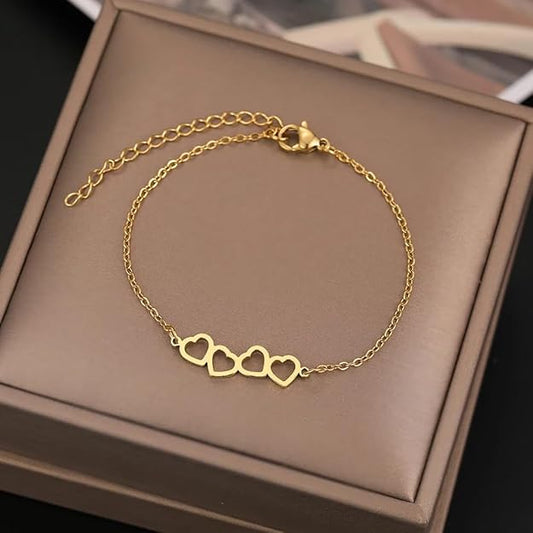 Gold bracelet featuring two heart pendants.
