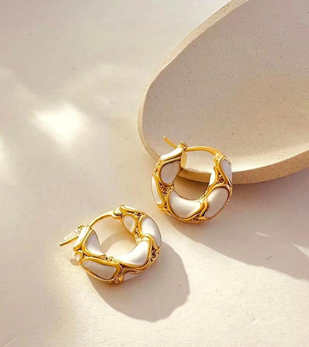 Two gold hoop earrings with white stones.
