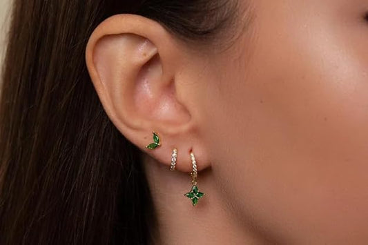 green earrings and a butterfly charm.