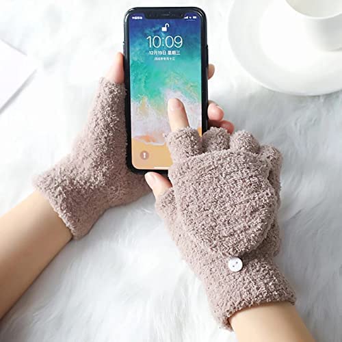 A person smiling while holding a phone, showcasing a stylish pair of gloves in the other hand.