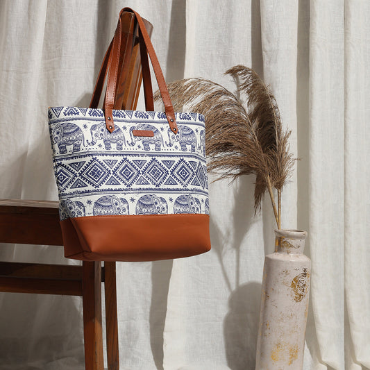 Chic tote bag with elephant pattern and sturdy brown leather straps for a fashionable look.