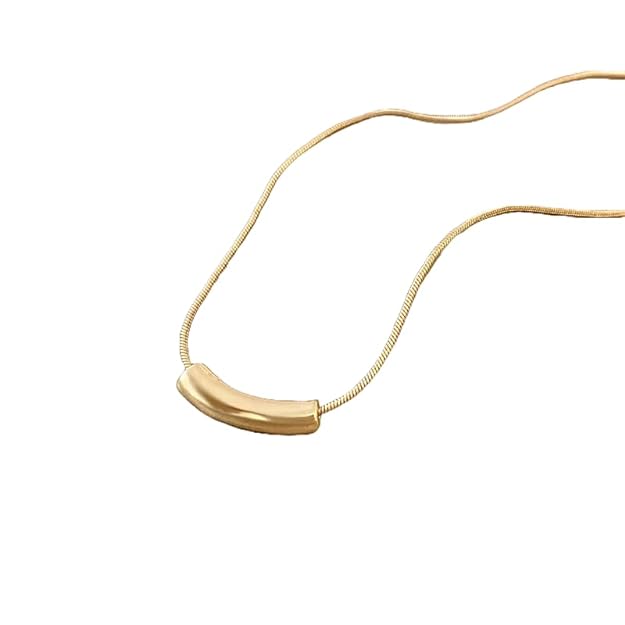 Luxurious gold necklace showcased on beige table.