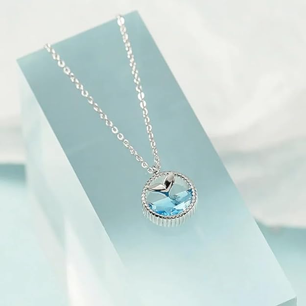 A silver chain necklace featuring a blue whale pendant.