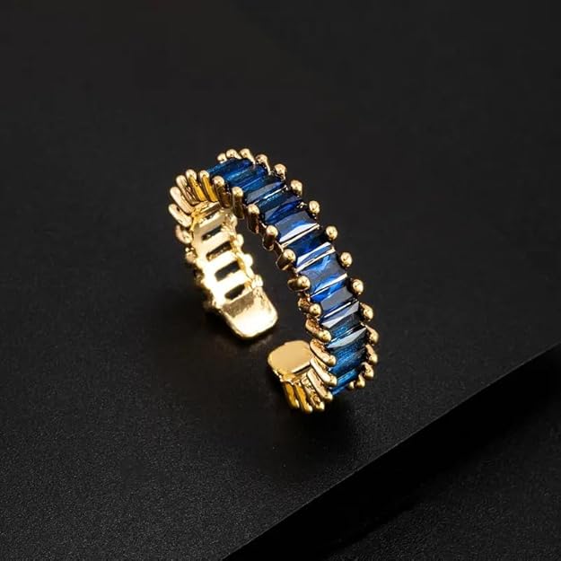 A stunning gold plated ring adorned with sparkling blue stones, perfect for adding a touch of elegance to any outfit.
