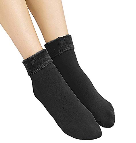 A woman's legs in black socks, elegantly displayed with a second pair of matching black socks positioned nearby.