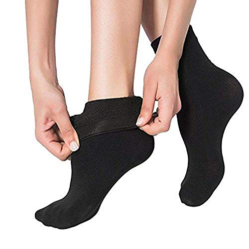 A close-up of a woman's legs wearing black socks, complemented by an additional pair of black socks beside them.