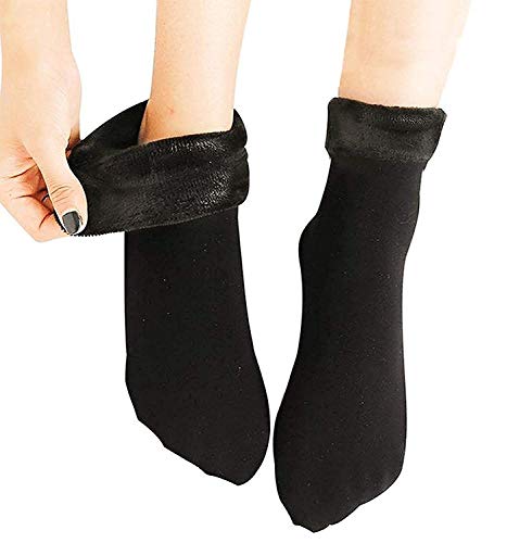 A woman's legs adorned in black socks, showcasing a stylish and coordinated look with another pair of black socks nearby.