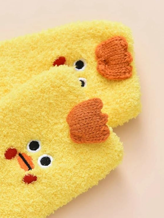 Close-up of a woman’s feet in bright yellow socks adorned with cute chicken faces, bringing a playful vibe to her look.