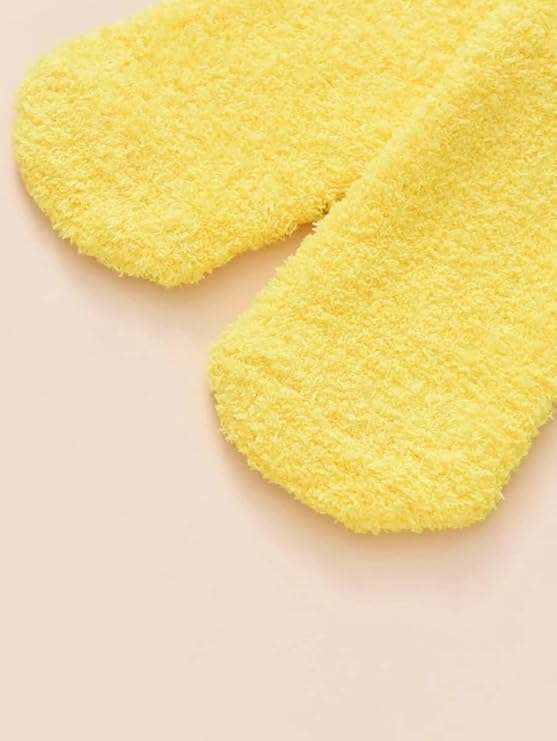 A woman’s feet in sunny yellow socks featuring cute chicken faces, adding a whimsical touch to her casual outfit.