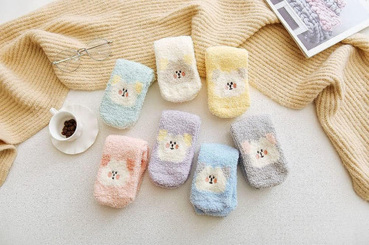 A pair of socks adorned with a pink bear, showcasing a fun and whimsical style for cozy wear.