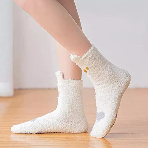 A close-up of a woman's legs wearing white socks adorned with a white owl design.