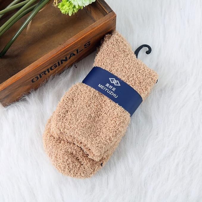A pair of colorful socks displayed alongside a rustic wooden box, showcasing a charming and cozy aesthetic.
