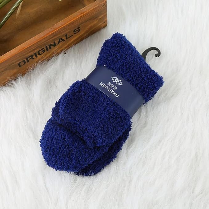 A cozy pair of blue fuzzy socks resting beside a charming wooden box, perfect for keeping your feet warm and stylish.