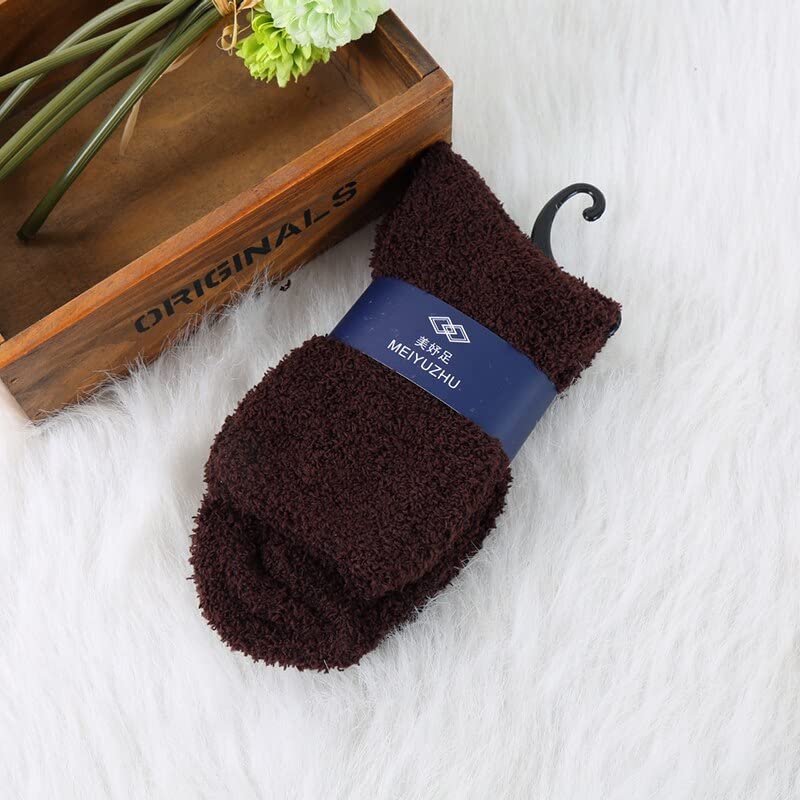 A cozy pair of brown socks resting beside a rustic wooden box on a soft surface.