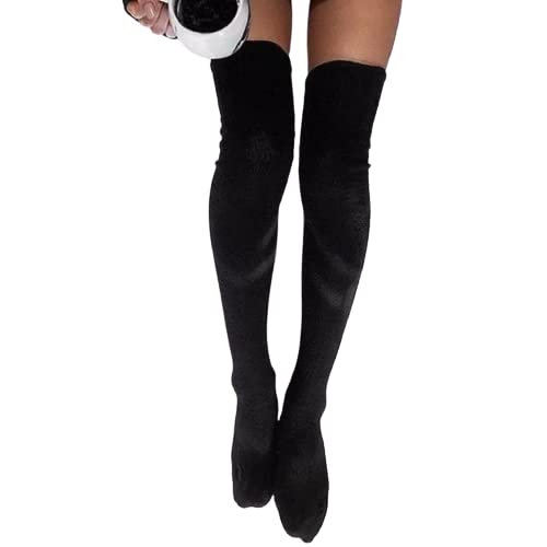 A woman in stylish black stockings holds a coffee cup, savoring a cozy moment with her drink.