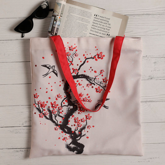 Stylish tote bag adorned with a bird and cherry blossom motif, a chic accessory for any occasion.