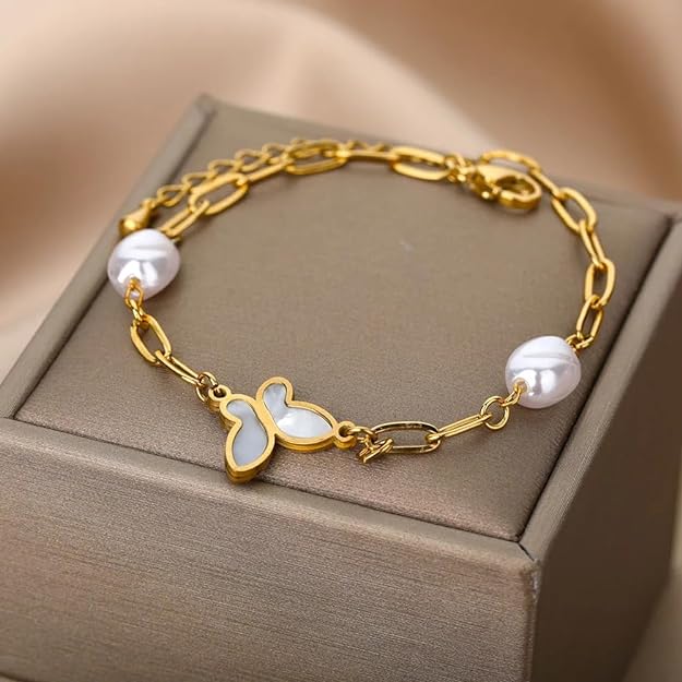 Shiny gold bracelet with white pearl and delicate butterfly charm.