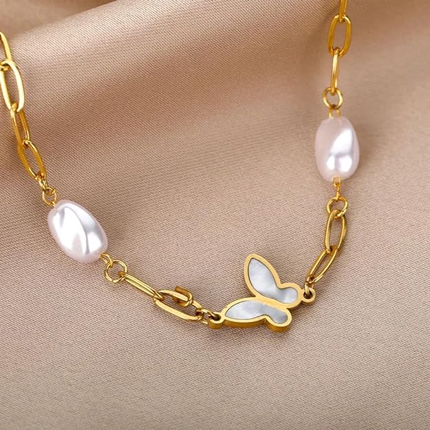 Chic gold bracelet with white pearl and charming butterfly detail.