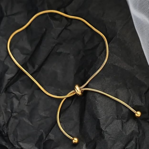 Delicate gold bracelet paired with a small gold chain, creating a stylish and timeless accessory.