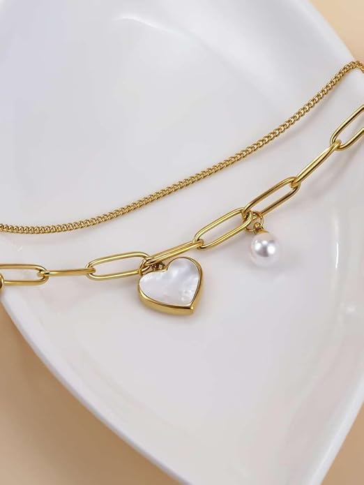  Dainty gold bracelet with heart charm and pearl, a timeless piece of jewelry.