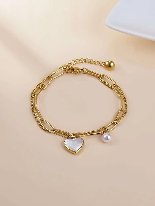 A delicate gold bracelet adorned with a heart charm and pearl.