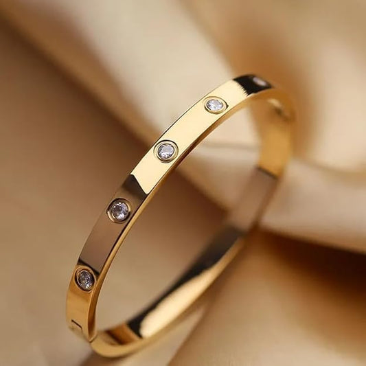 A gold bracelet with two hearts on it.