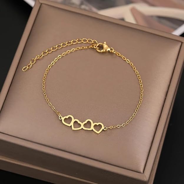  Gold bracelet featuring two heart pendants.