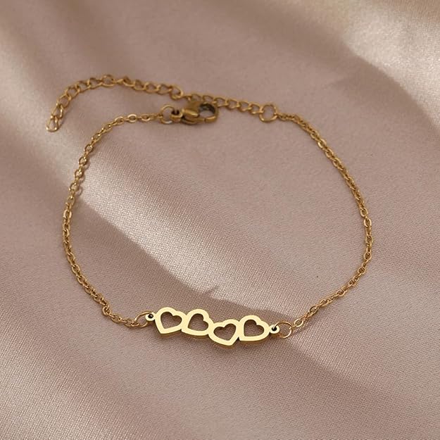 A gold bracelet with a pair of heart-shaped decorations.