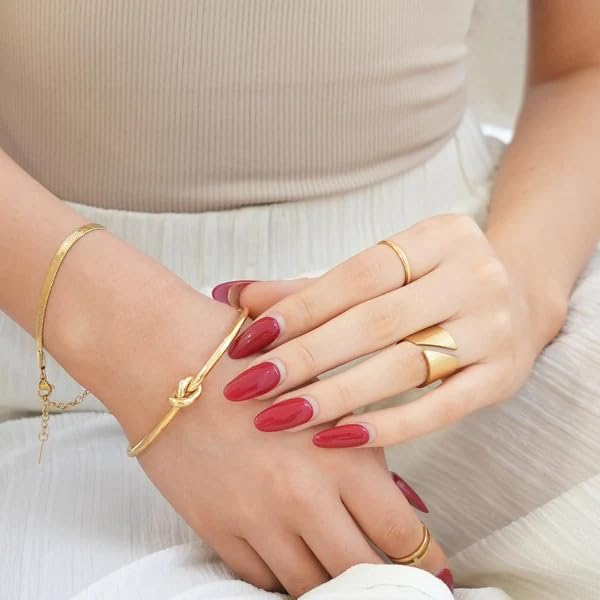 Gold cuff bracelet adorned with a beautiful knot design, a versatile piece that complements any ensemble.