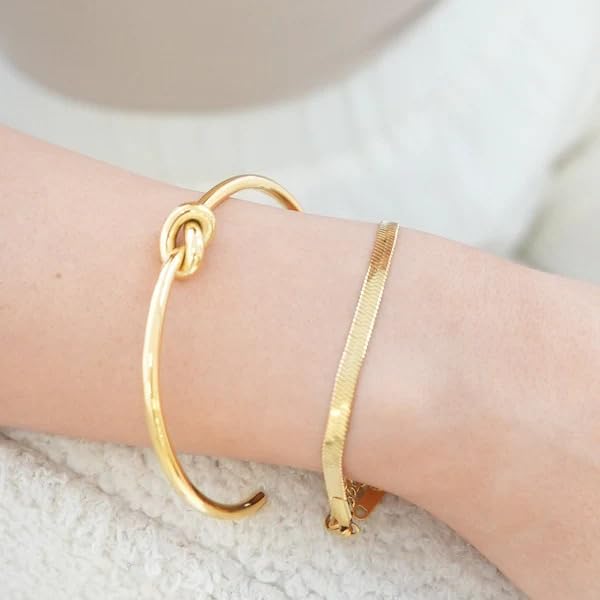  Chic gold cuff bracelet with intricate knot detailing, a must-have accessory for a touch of glamour.