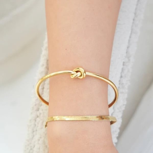  Elegant gold cuff bracelet with a knot design, a timeless accessory that adds a touch of sophistication to your look.