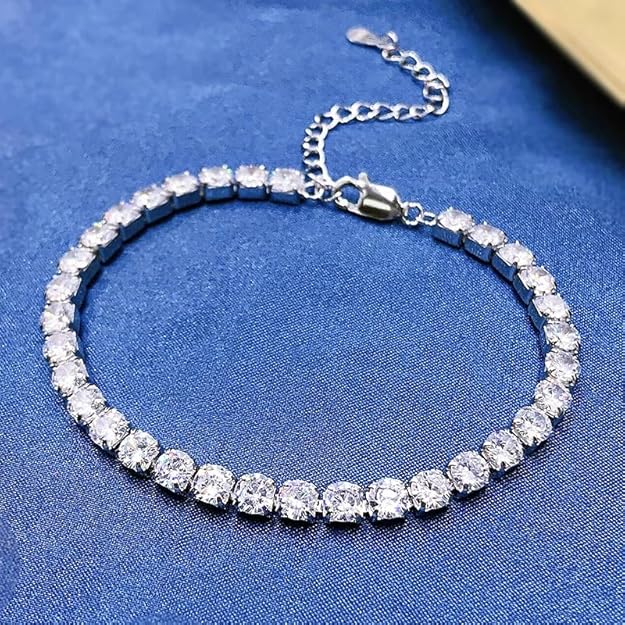 A diamond tennis bracelet resting on a blue surface.