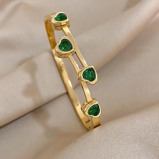 A luxurious gold plated bracelet adorned with stunning green stones.