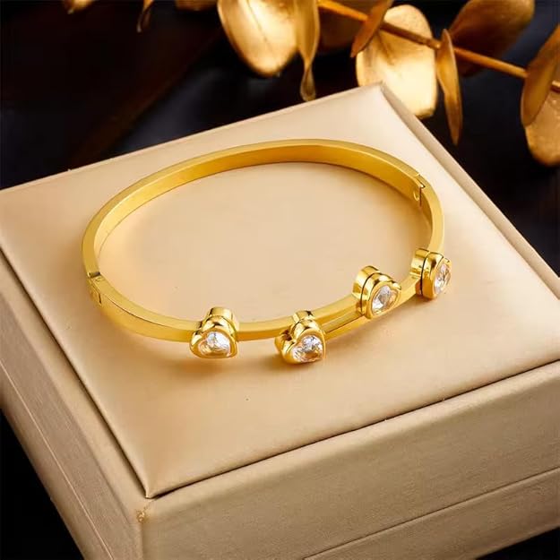 Stylish gold bracelet featuring three heart pendants, ideal for a chic and romantic look.