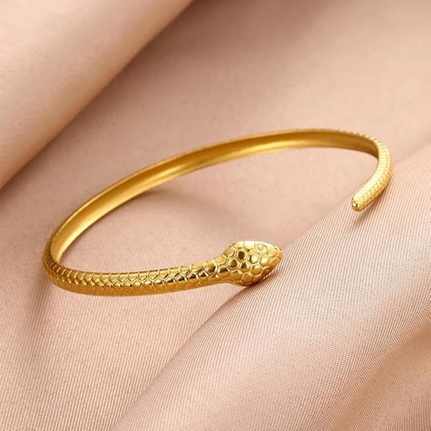 Elegant gold snake bracelet showcased on a box.