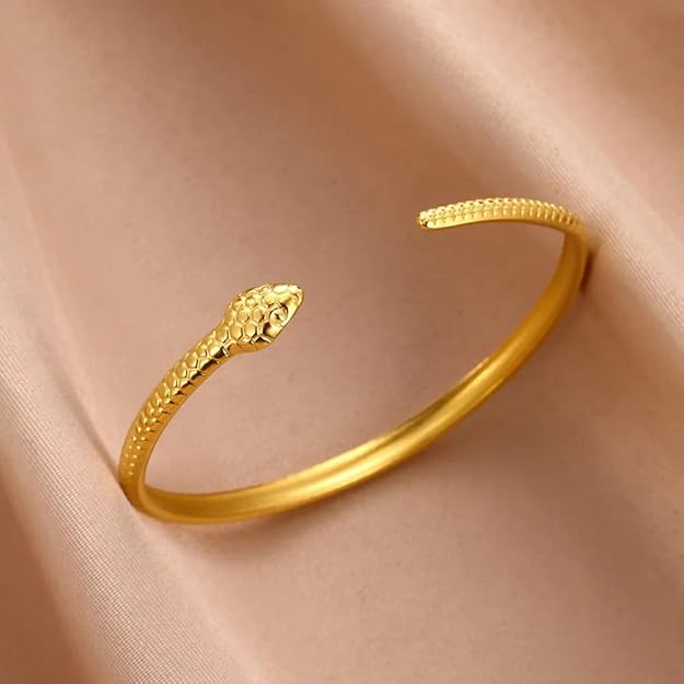 A luxurious gold snake bracelet placed on a box.