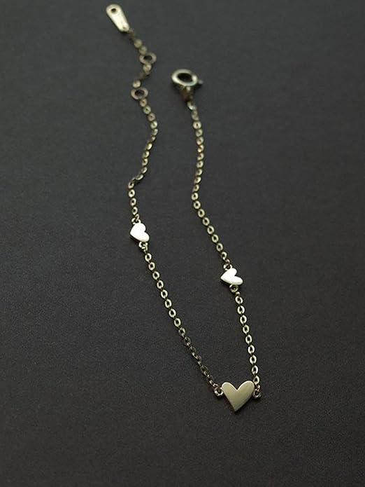 A stylish gold bracelet with heart-shaped pendants.