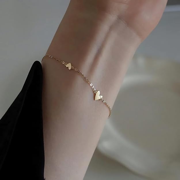 A chic gold chain bracelet adorned with heart charms.