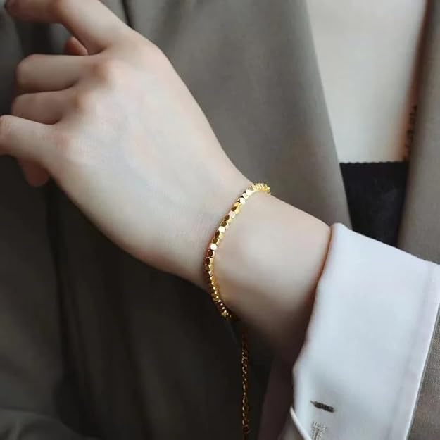 Woman with gold bracelet on wrist.