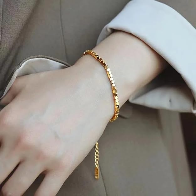 Gold bracelet on a woman's wrist, symbolizing beauty and grace.