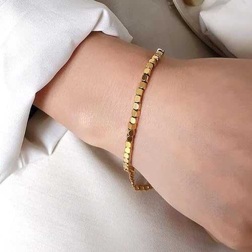 A woman with a gold bracelet on her wrist, showcasing elegance and style.