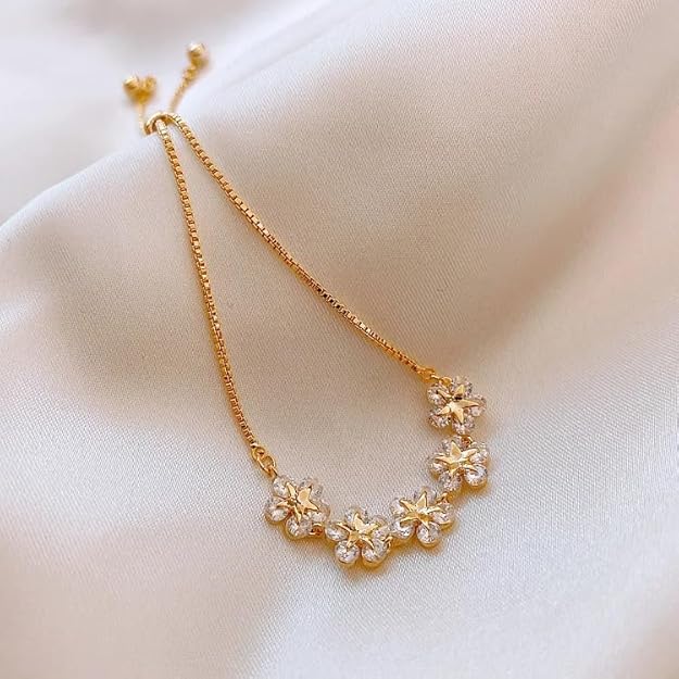 Dainty flowers on a shiny gold bracelet.