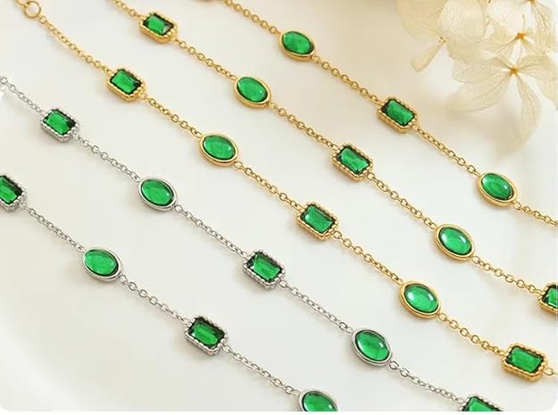 Add a pop of color to your look with this gold chain bracelet embellished with vibrant green stones.