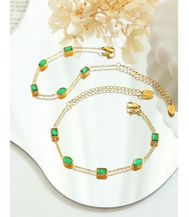 Gold chain bracelet with green stones, elegant and stylish jewelry accessory.