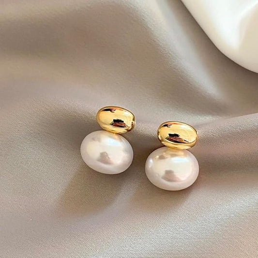 White pearl earrings on white cloth, elegant and classic jewelry accessory.