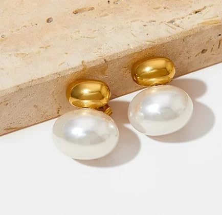 White pearl earrings elegantly placed on white cloth, a timeless and versatile accessory.