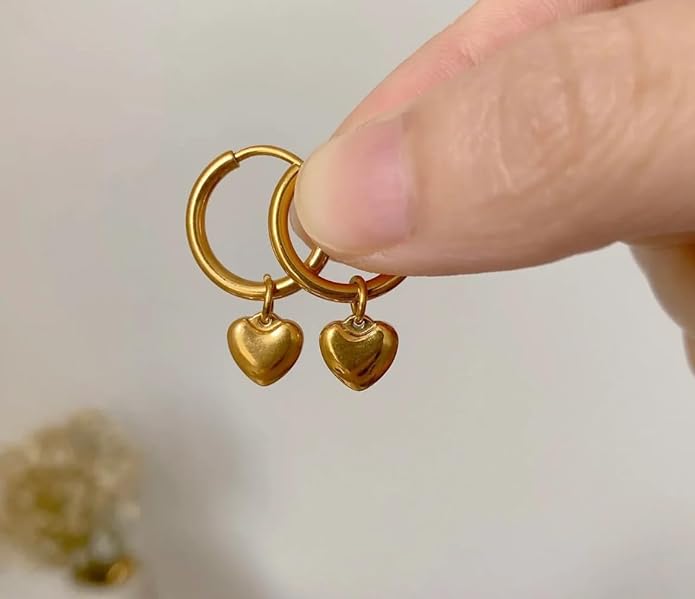 Gold heart-shaped hoop earrings on a plate.