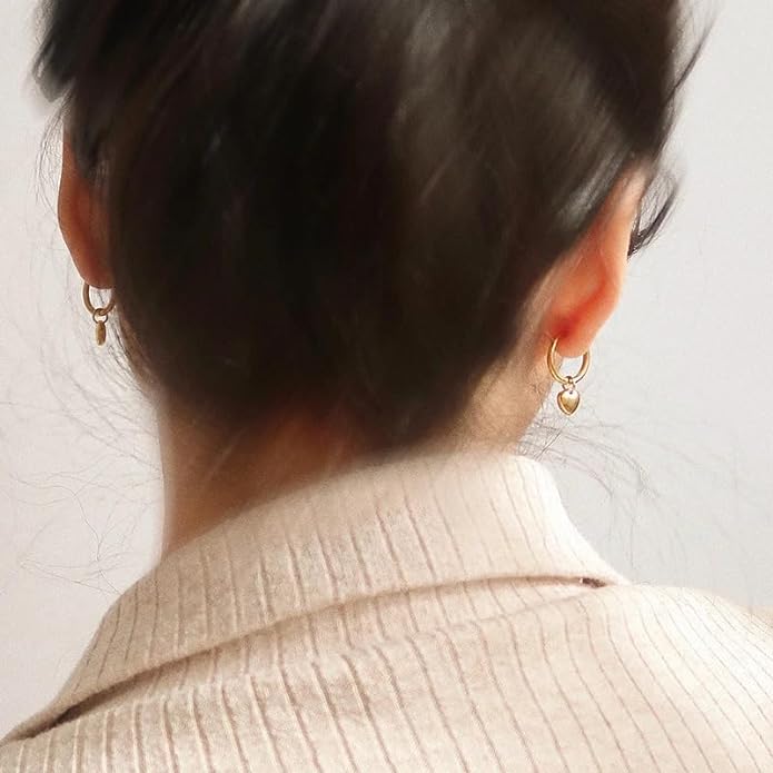 Gold heart-shaped earrings on a plate.